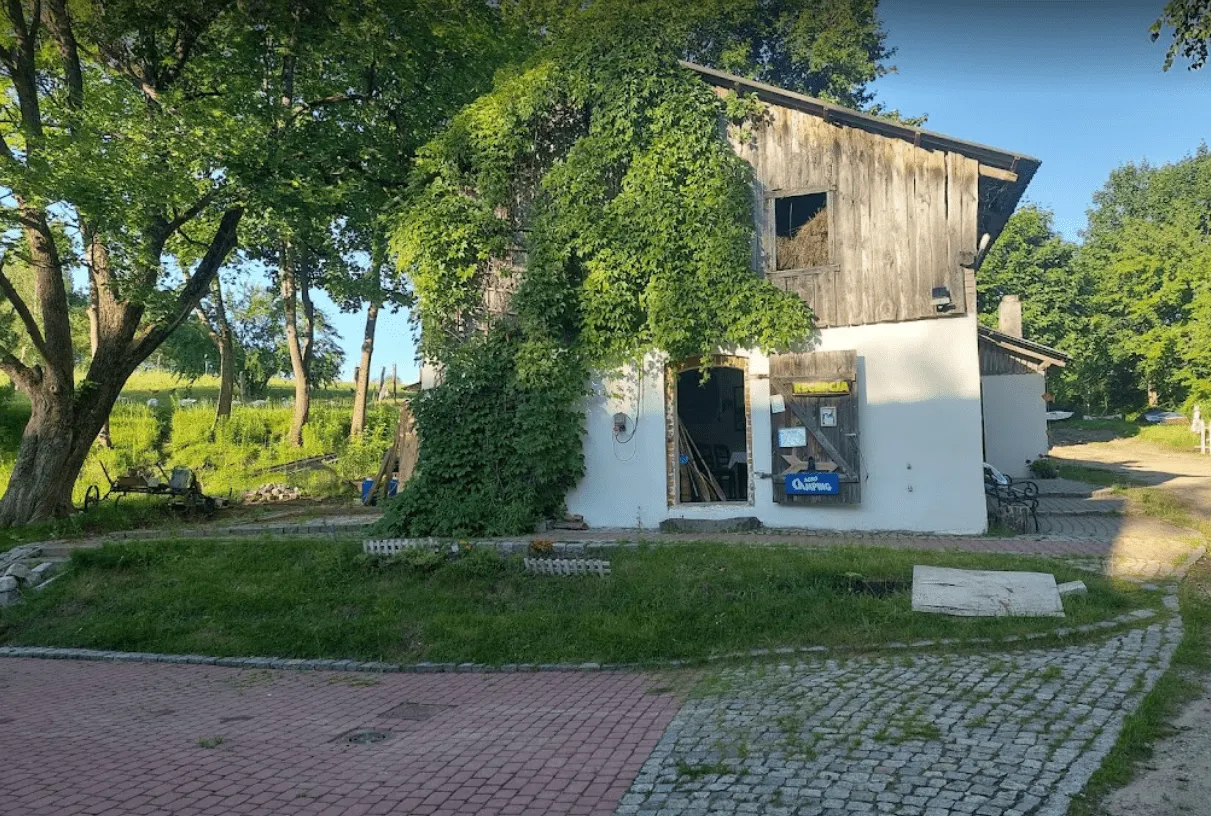 Zufahrt und Rezeption des Campingplatzes zwischen grünen Bäumen
